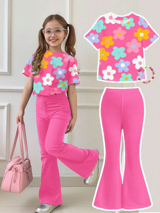 a short-sleeved top with a colorful floral print and bright pink flared trousers.